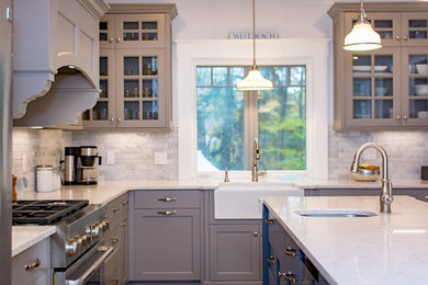 This is an example of a mid-sized traditional l-shaped kitchen in Boston with a farmhouse sink, beaded inset cabinets and medium hardwood floors.