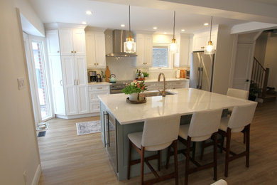 Example of a large trendy single-wall vinyl floor and beige floor eat-in kitchen design in Toronto with an undermount sink, recessed-panel cabinets, white cabinets, quartz countertops, stainless steel appliances, an island and white countertops