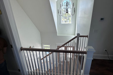 Elegant wooden l-shaped wood railing and wainscoting staircase photo in Charleston with wooden risers