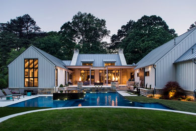 Example of a large farmhouse backyard concrete paver and custom-shaped infinity pool fountain design in Atlanta