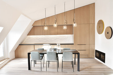 Idée de décoration pour une cuisine américaine design en bois clair avec un plan de travail en béton, un plan de travail gris, un placard à porte plane, une crédence blanche, parquet clair et un sol beige.