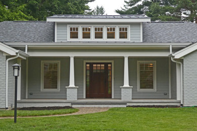 This is an example of a transitional front porch design in Cincinnati with a roof extension.