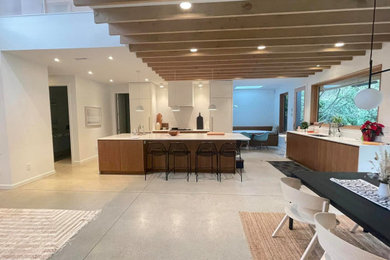 Example of a mid-sized minimalist concrete floor, gray floor and exposed beam kitchen/dining room combo design in Vancouver with white walls