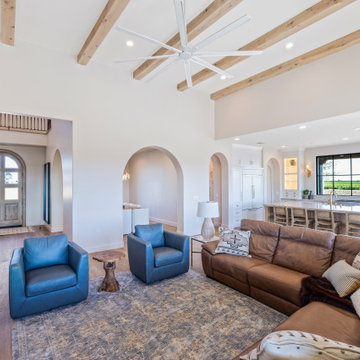 Great Room with Curved Staircase and Blue Accent Chairs | Tuscan Farmhouse