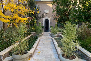 Patio container garden - large french country courtyard stone patio container garden idea in Los Angeles with no cover