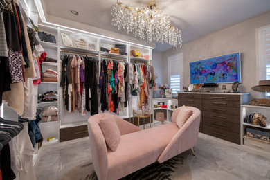 This is an example of a medium sized modern walk-in wardrobe for women in Denver with flat-panel cabinets, white cabinets, marble flooring and grey floors.