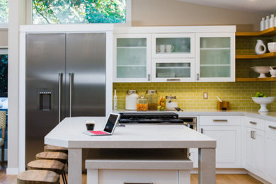 Inspiration for a transitional light wood floor, beige floor and vaulted ceiling kitchen remodel in San Francisco with a farmhouse sink, shaker cabinets, white cabinets, quartz countertops, green backsplash, ceramic backsplash, stainless steel appliances, an island and white countertops