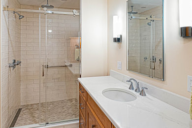 Inspiration for a mid-sized transitional master bathroom in Newark with shaker cabinets, medium wood cabinets, an alcove shower, a two-piece toilet, white tile, an undermount sink, engineered quartz benchtops, a sliding shower screen, white benchtops, a shower seat, a single vanity and a built-in vanity.