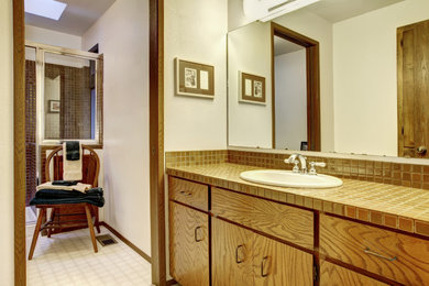 Bathroom - large traditional master beige tile and subway tile laminate floor, beige floor and single-sink bathroom idea in Houston with flat-panel cabinets, brown cabinets, a built-in vanity, tile countertops and orange countertops