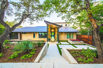 Trendy one-story stone exterior home photo in Austin with a shed roof