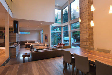 Living room - mid-sized contemporary formal and open concept medium tone wood floor and brown floor living room idea in Calgary with beige walls and no fireplace