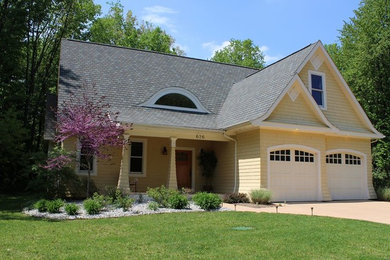 Example of a mid-sized yellow two-story concrete fiberboard exterior home design in Grand Rapids