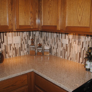 Updated quartz countertops and modern glass tile backsplashes
