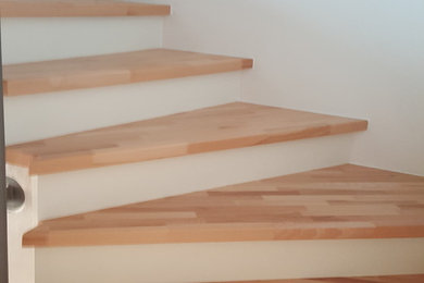 Свежая идея для дизайна: изогнутая деревянная лестница среднего размера в современном стиле с деревянными ступенями - отличное фото интерьера