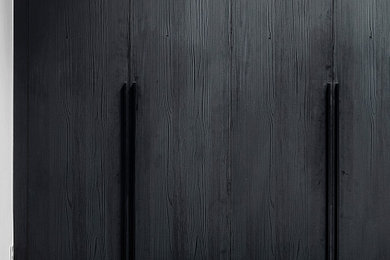 Ejemplo de armario y vestidor unisex de tamaño medio con a medida, armarios con paneles lisos, puertas de armario de madera en tonos medios, suelo de cemento y suelo gris