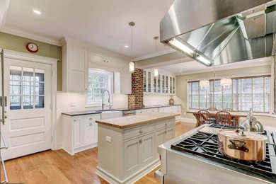 Eat-in kitchen - huge transitional u-shaped medium tone wood floor eat-in kitchen idea with a farmhouse sink, beaded inset cabinets, white cabinets, soapstone countertops, white backsplash, subway tile backsplash, stainless steel appliances, an island and gray countertops