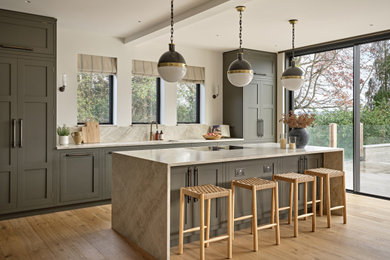 Inspiration for a large classic kitchen in Surrey with shaker cabinets, green cabinets, engineered stone countertops, beige splashback, an island and beige worktops.