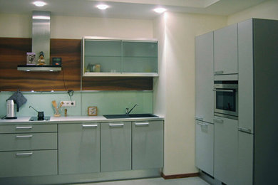 Inredning av ett modernt mellanstort kök, med en dubbel diskho, släta luckor, grå skåp, bänkskiva i koppar, grått stänkskydd, glaspanel som stänkskydd, rostfria vitvaror, klinkergolv i porslin och grått golv