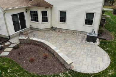 Inspiration for a mid-sized traditional backyard stone landscaping in Other.