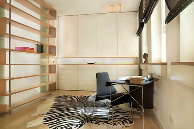 This is an example of a large contemporary study room in Munich with white walls, light hardwood floors, no fireplace and a freestanding desk.