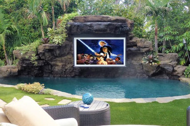 Example of a mid-sized island style backyard custom-shaped pool design in Los Angeles