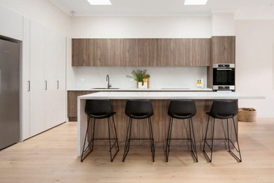 Mid-sized contemporary l-shaped kitchen in Melbourne with quartz benchtops and engineered quartz splashback.