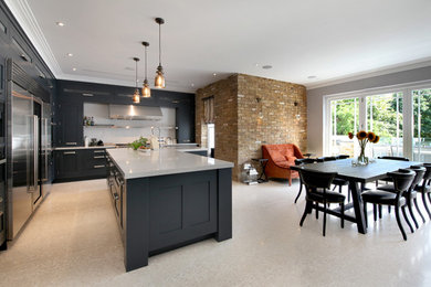 Inspiration for a contemporary l-shaped eat-in kitchen in Surrey with shaker cabinets, black cabinets, white splashback, stainless steel appliances, with island and beige floor.