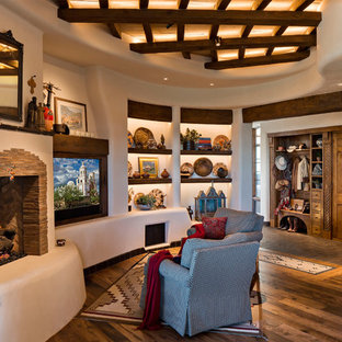 Großes, Offenes Mediterranes Wohnzimmer mit beiger Wandfarbe, Multimediawand, braunem Boden, braunem Holzboden, Kamin und Kaminsims aus Stein in Phoenix