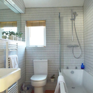 Aménagement d'une petite salle de bain pour enfant avec un placard à porte plane, des portes de placard blanches, une baignoire posée, un combiné douche/baignoire, un WC séparé, un carrelage blanc, carrelage en mosaïque, un mur blanc, un sol en liège et un lavabo suspendu.