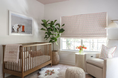 Diseño de habitación de bebé niña clásica renovada de tamaño medio con paredes blancas, suelo de madera clara, suelo marrón y papel pintado