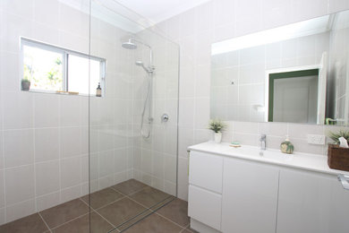 Photo of a 3/4 bathroom in Cairns with an open shower, an integrated sink and an open shower.