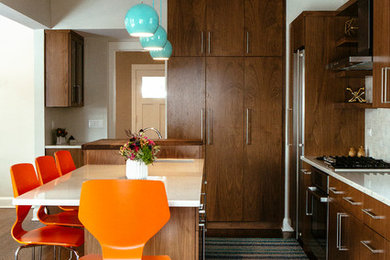 This is an example of a midcentury kitchen in Chicago with medium wood cabinets, white splashback, ceramic splashback, medium hardwood floors, with island and brown floor.