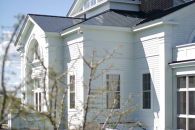 Example of a classic white two-story wood exterior home design in New York with a hip roof