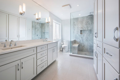 Example of a mid-sized transitional master gray tile, white tile and porcelain tile porcelain tile doorless shower design in Toronto with shaker cabinets, a one-piece toilet, white walls, an undermount sink, solid surface countertops and gray cabinets