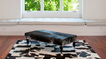 Grey speckle cowhide ottoman with wood legs & chrome wheels