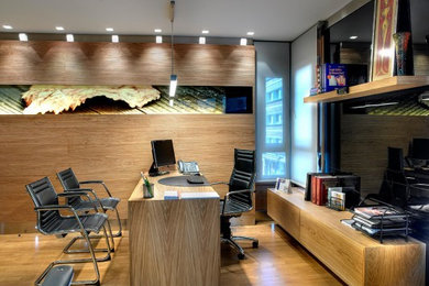 Ejemplo de despacho minimalista con paredes marrones, suelo de madera en tonos medios, escritorio independiente y suelo beige