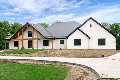 Country white one-story brick house exterior idea in Cincinnati with a hip roof, a metal roof and a black roof