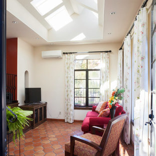 Esempio di un soggiorno mediterraneo di medie dimensioni e aperto con nessun camino, pareti bianche, pavimento in terracotta, TV autoportante e pavimento arancione