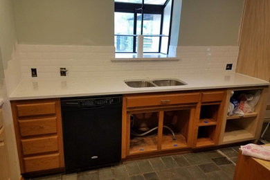 Minimalist kitchen photo in Dallas with light wood cabinets and ceramic backsplash
