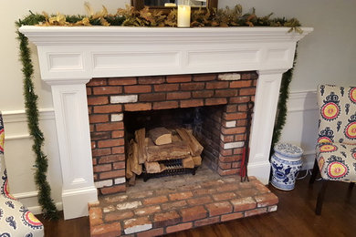 Example of a mid-sized classic enclosed dark wood floor family room design in Boston with gray walls, a standard fireplace and a wood fireplace surround