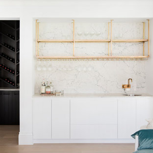 シドニーの中サイズのビーチスタイルのおしゃれなウェットバー (アンダーカウンターシンク、白いキャビネット、白いキッチンパネル、白いキッチンカウンター) の写真