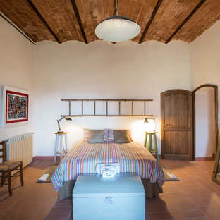 Idéer för mellanstora lantliga huvudsovrum, med vita väggar, tegelgolv och brunt golv