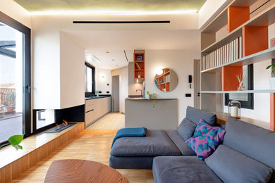 Diseño de sala de estar abierta actual pequeña con suelo de madera en tonos medios, chimenea de esquina, marco de chimenea de metal y suelo marrón