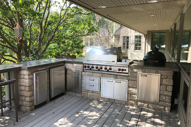 Outdoor kitchen deck photo in Other with a roof extension