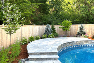 Modelo de jardín clásico renovado grande en verano en patio trasero con brasero, exposición total al sol, adoquines de hormigón y con metal