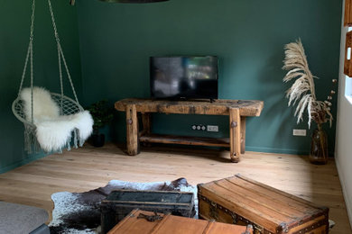 Idées déco pour un grand salon campagne ouvert avec un mur vert, un sol en bois brun, un poêle à bois, un manteau de cheminée en carrelage, un sol marron et un plafond en bois.