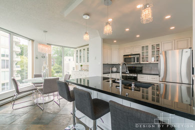 Mid-sized transitional l-shaped slate floor and multicolored floor eat-in kitchen photo in Vancouver with an undermount sink, raised-panel cabinets, white cabinets, granite countertops, gray backsplash, porcelain backsplash, stainless steel appliances and an island