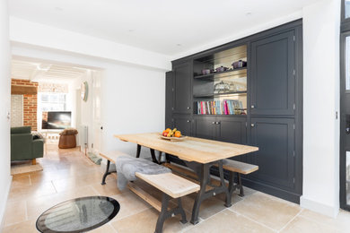Photo of a medium sized modern open plan dining room in Hertfordshire with white walls, porcelain flooring, beige floors and feature lighting.