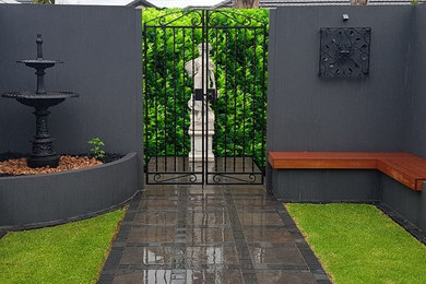 Photo of a mid-sized traditional courtyard partial sun formal garden in Adelaide with concrete pavers.