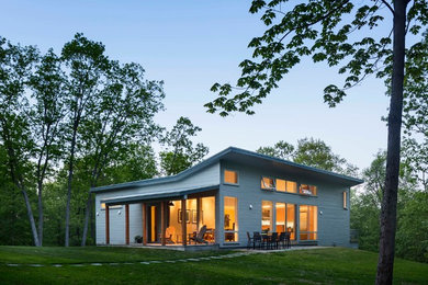 Mid-sized modern two-storey grey house exterior in New York with wood siding and a flat roof.